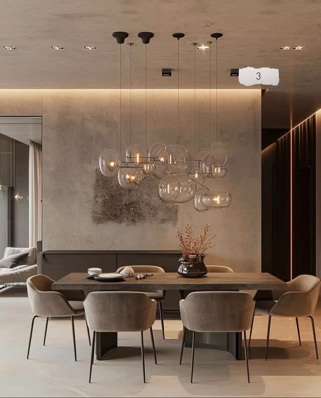 Modern dining room with a large glass bubble chandelier, wooden table, and beige upholstered chairs.