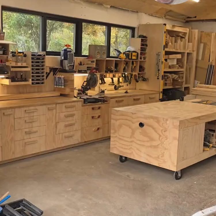 Light wood plywood garage cabinets and drawers installed along a wall with a mobile workbench.