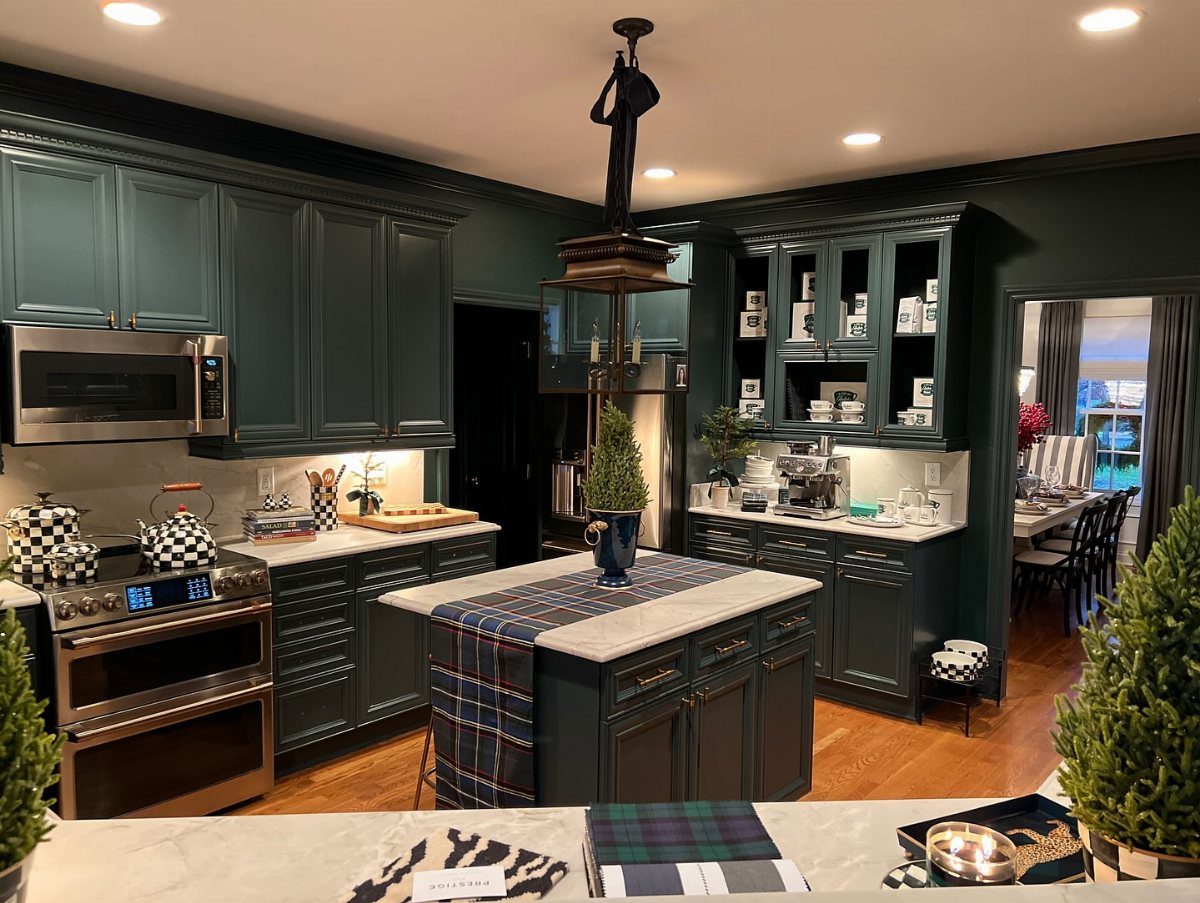 Dark teal kitchen cabinetry with a central island, stainless steel appliances, and plaid accents.